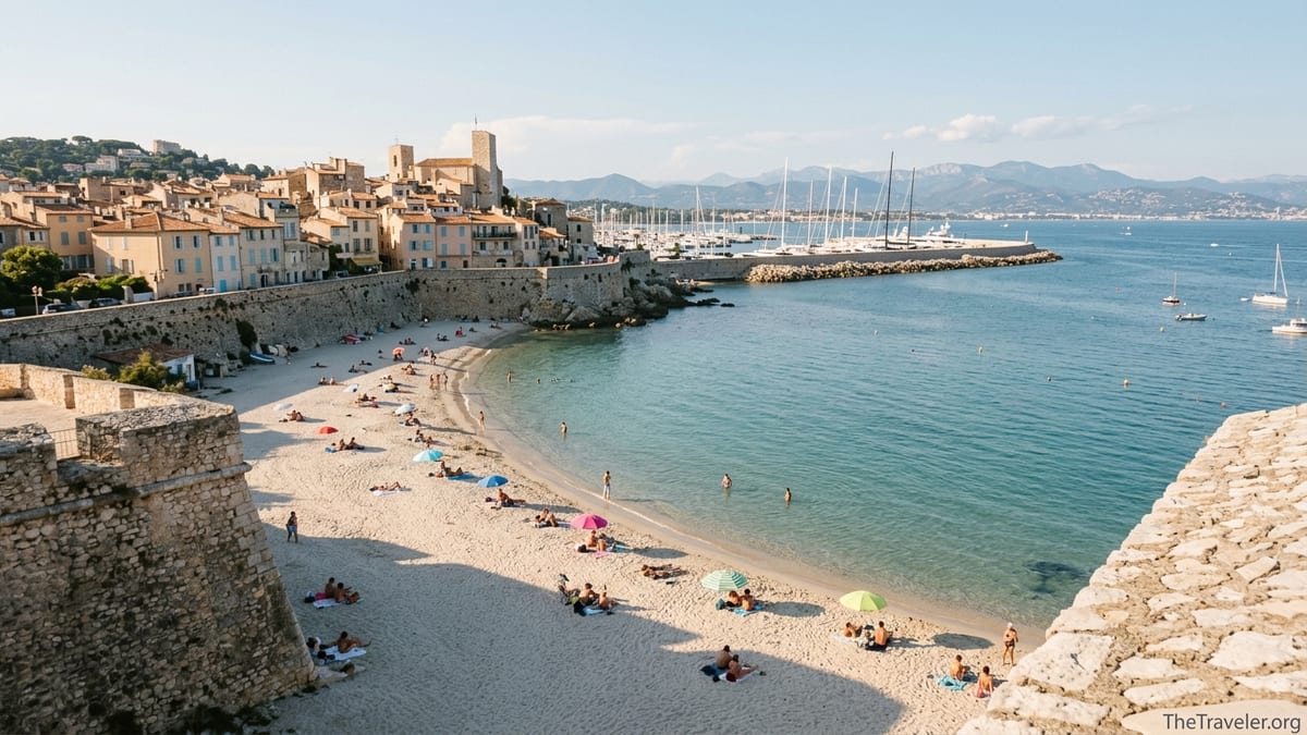 View from Antibes ramparts over Plage de la Gravette, marina and old town on a clear summer afternoon.