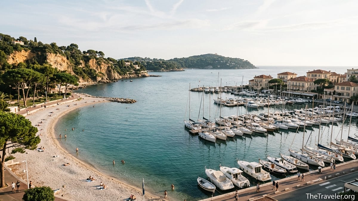 View over Beaulieu-sur-Mer marina and Petite Afrique beach with cliffs, pines and turquoise sea.