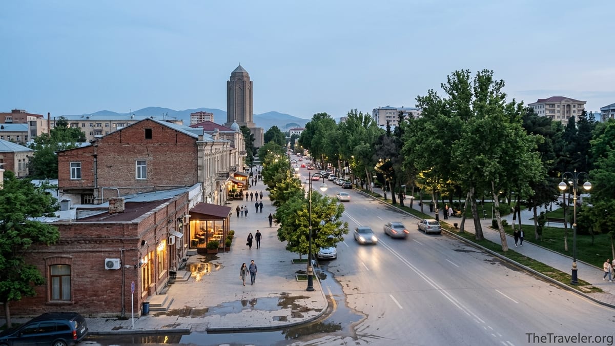 Evening street scene in central Ganja, Azerbaijan, with people walking and distant hills.