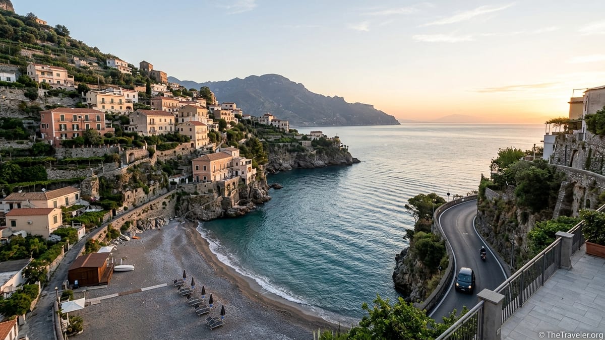 Quiet Amalfi Coast beach at sunrise in early autumn with light traffic on coastal road.