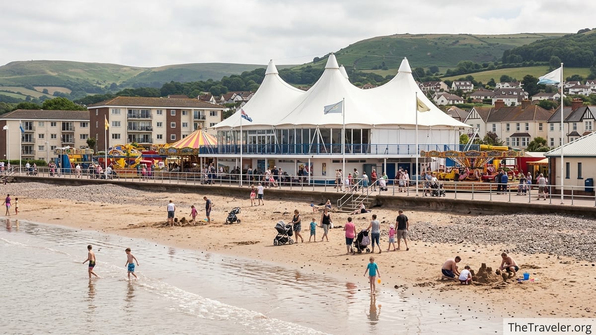 A wide view of Butlin’s Minehead showing the Skyline Pavilion, funfair and beach on a busy summer day.