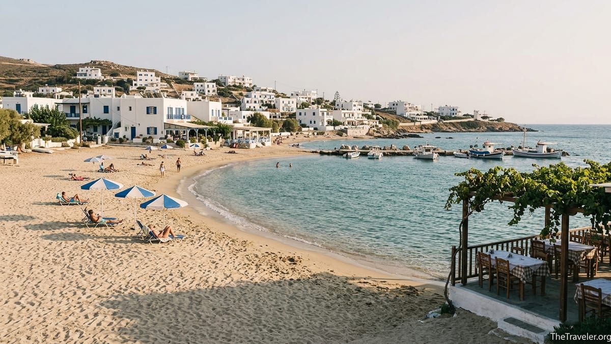 Quiet sandy beach on a Cycladic island with whitewashed houses and simple seafront tavernas.