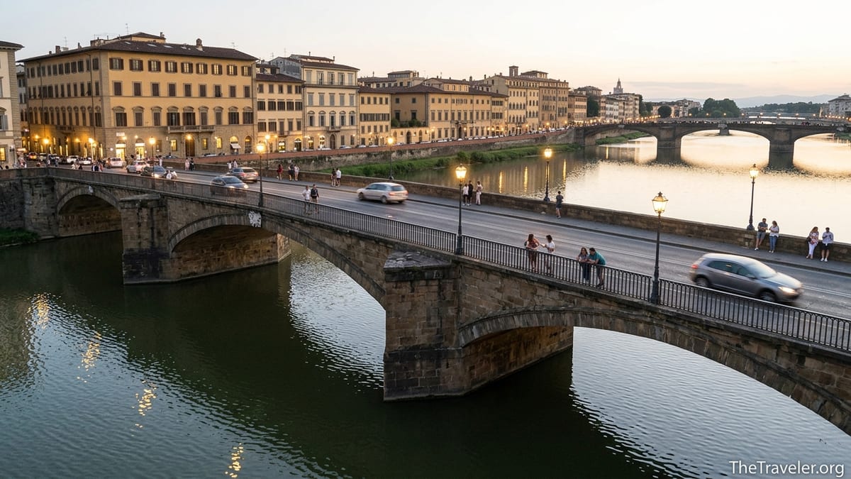 Evening view of Ponte alla Carraia in Florence with people walking and cars crossing over the Arno River.