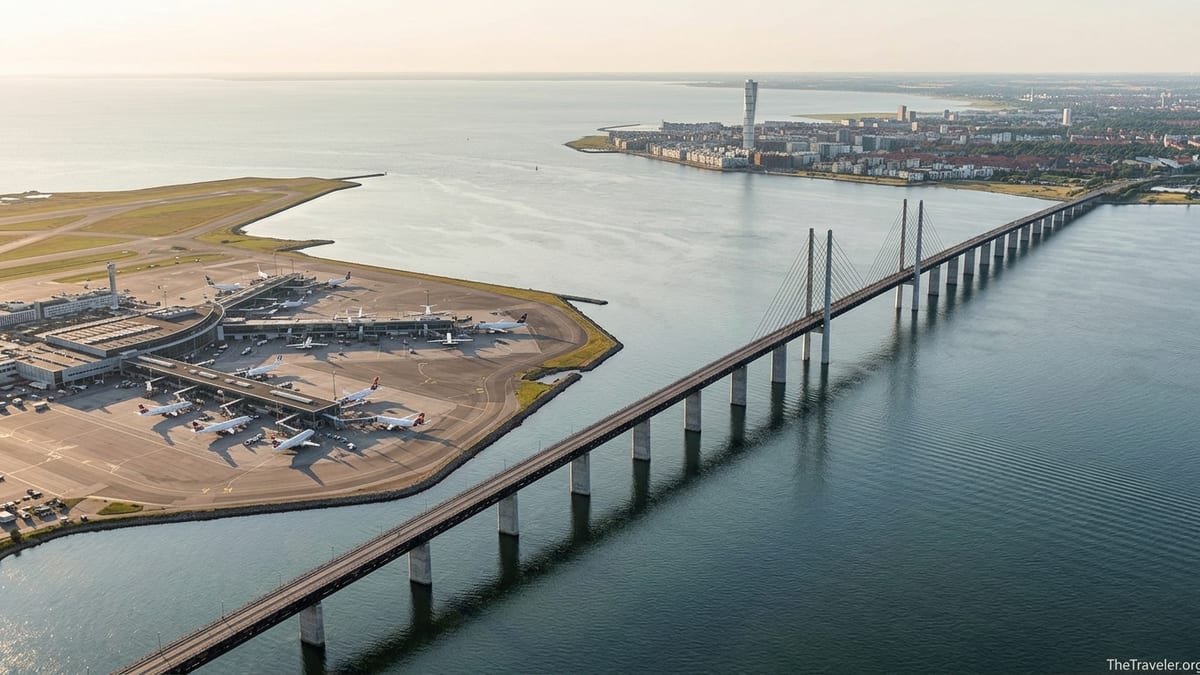 Aerial view of Copenhagen Airport and the Øresund Bridge leading toward Malmö at sunset.