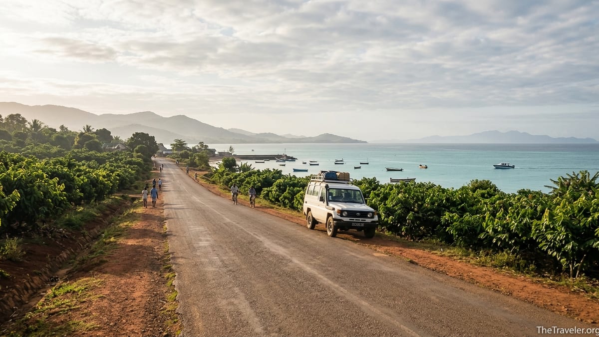 Coastal road near Ankify with a 4x4 and boats heading toward Nosy Be at sunrise.