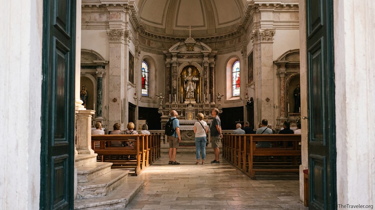Interior of Dubrovnik’s Church of St Blaise with visitors looking toward the main altar and silver statue.