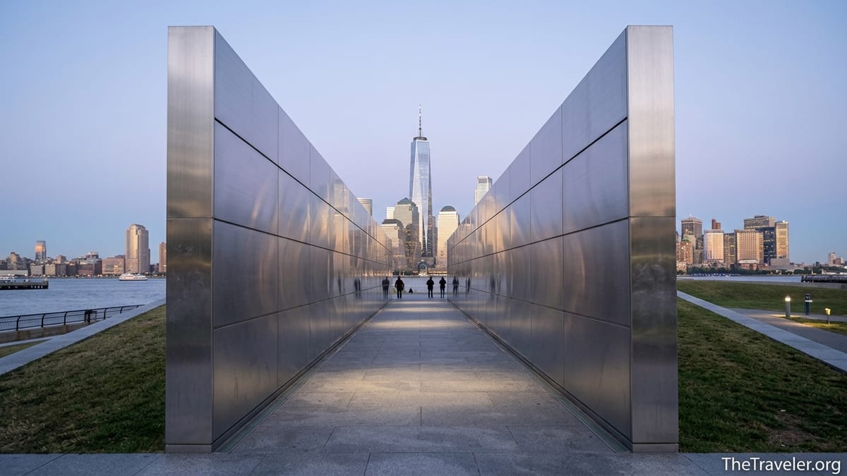 Empty Sky Memorial corridor in Liberty State Park facing the Manhattan skyline at dusk.