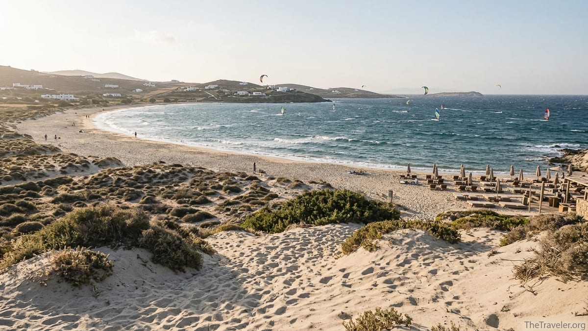 Windy afternoon view over Ftelia Beach in Mykonos with kites on choppy sea and wide sandy bay.
