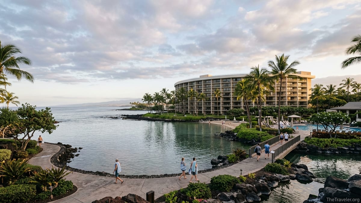 Ocean Tower Waikoloa Village overlooking a calm lagoon at sunrise with guests walking along the shore.