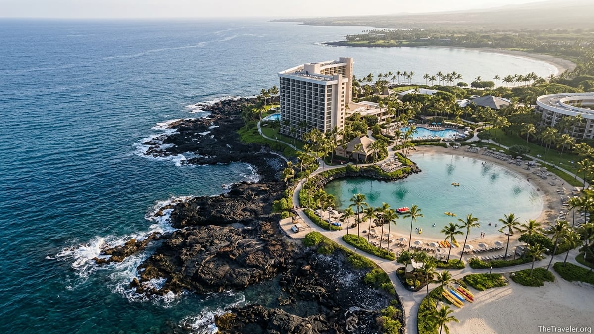 Aerial view of Hilton Waikoloa Ocean Tower on lava shoreline with lagoon and ocean.
