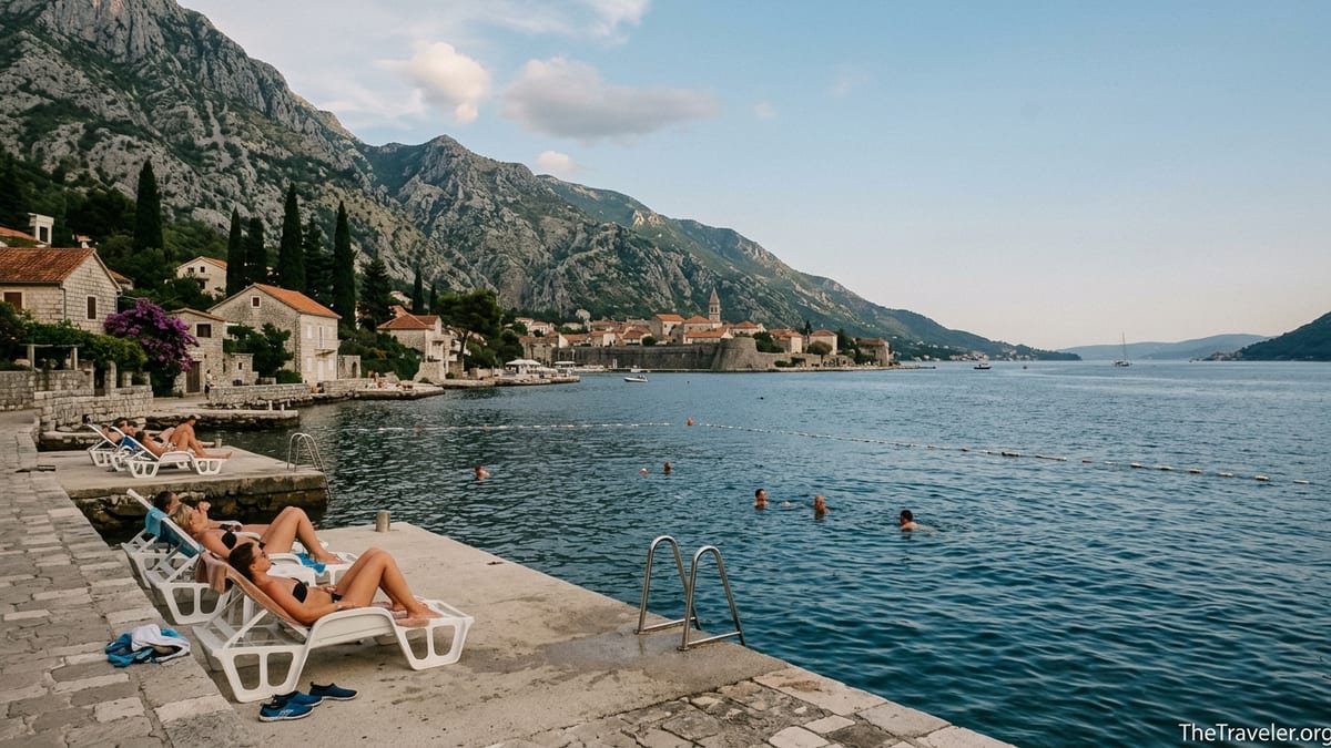 Swimming platform and loungers on the Bay of Kotor facing Kotor old town and surrounding mountains.