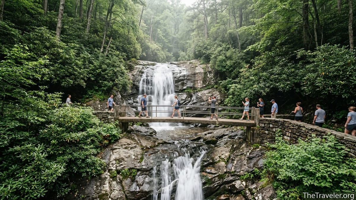 Hikers stand on the narrow bridge at Laurel Falls surrounded by lush green forest in Great Smoky Mountains National Park.