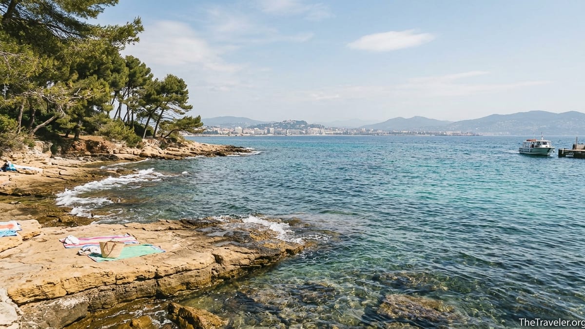 Rocky cove on Île Sainte-Marguerite with clear turquoise water and view back to Cannes.