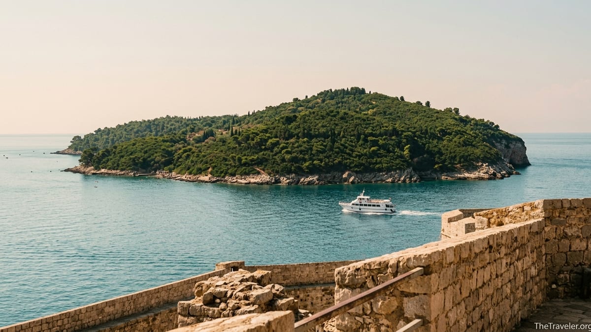 View from Dubrovnik’s Old Town walls across calm sea to forested Lokrum Island with a ferry crossing.