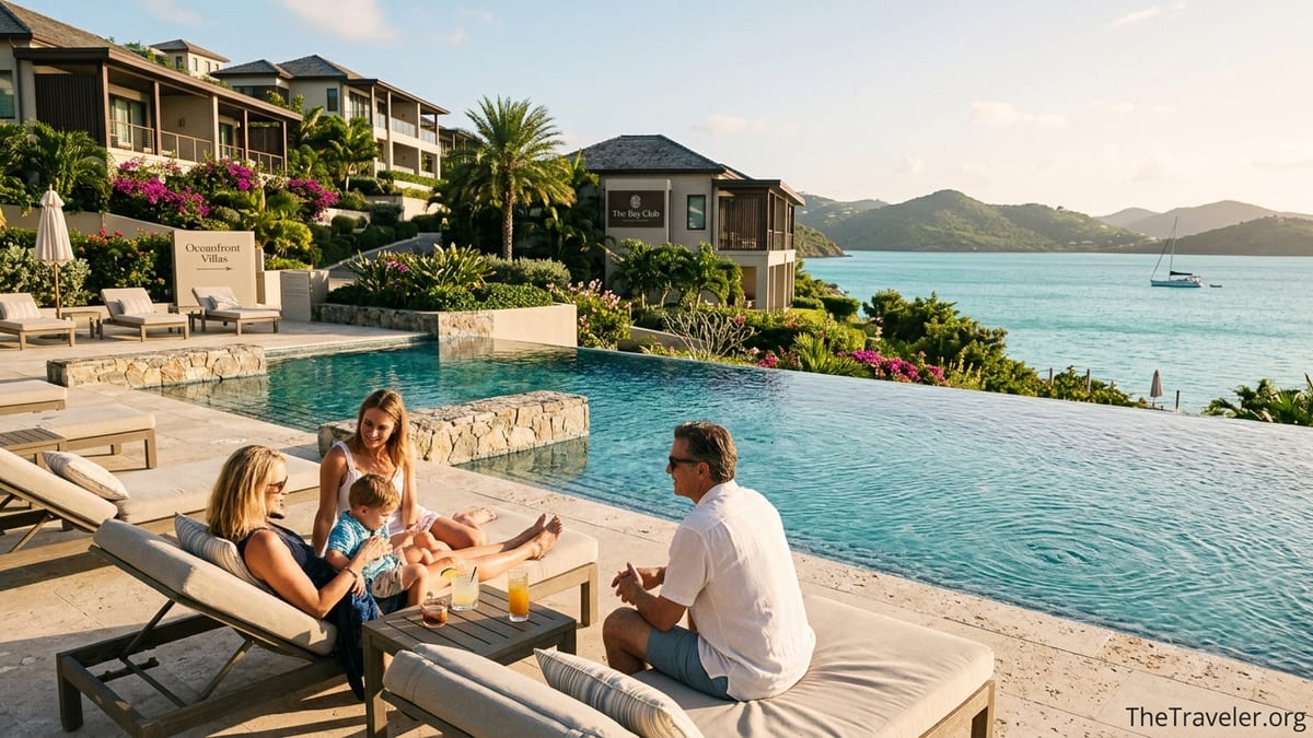 Luxury resort infinity pool terrace with private villas overlooking a calm tropical bay at sunset.