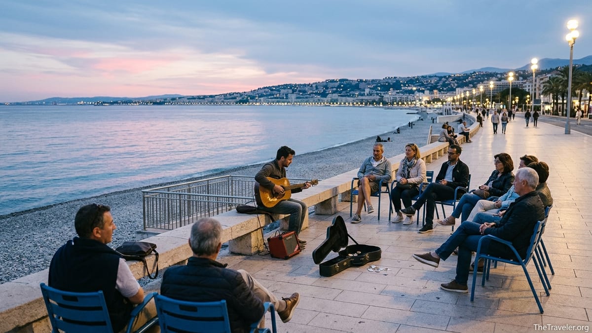 Street guitarist playing softly at blue hour on the Promenade des Anglais in Nice.