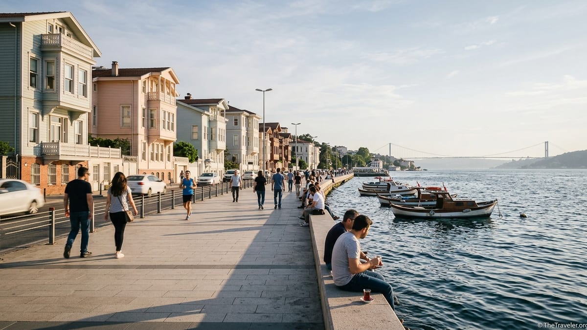 People walking along the Bosphorus waterfront between Arnavutköy and Bebek with wooden mansions and boats at sunset.