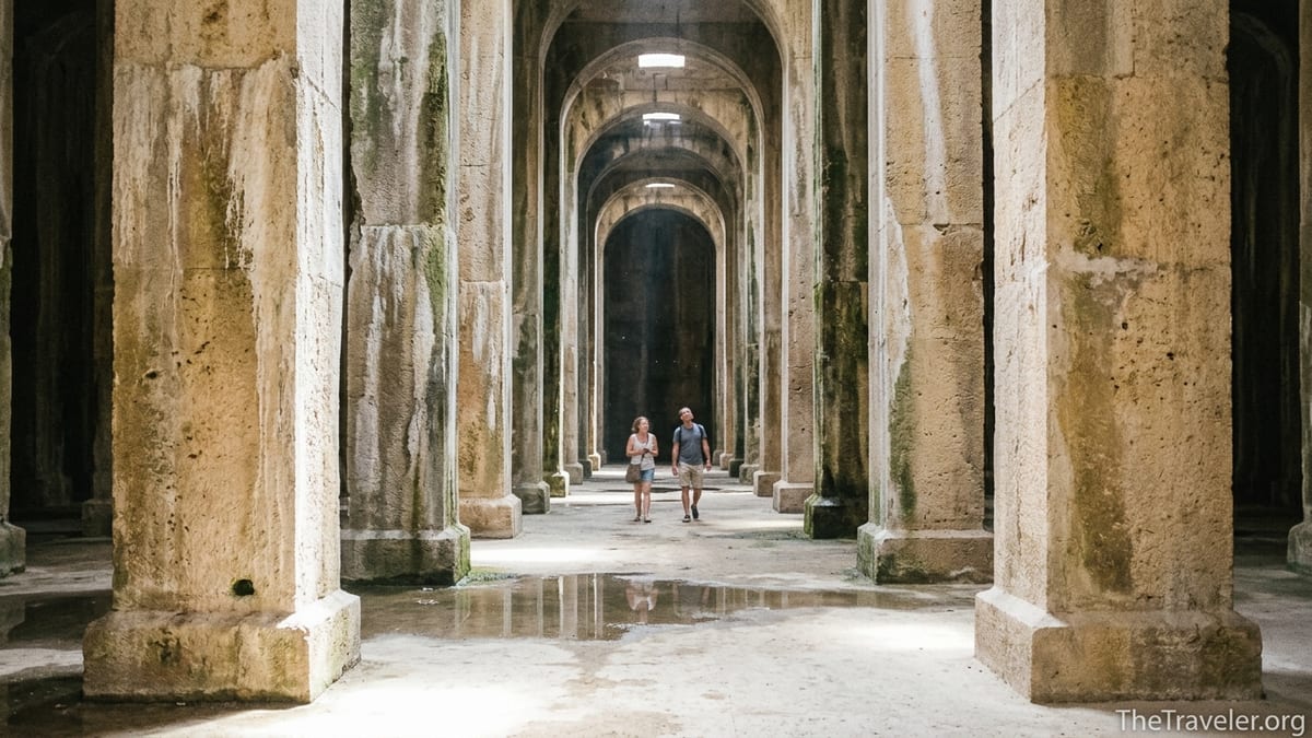 Interior of Piscina Mirabilis cistern in Bacoli with tall stone pillars and soft light from above.