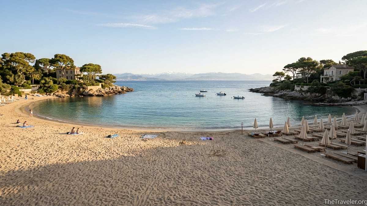 Early-morning view of Plage de la Garoupe with calm turquoise sea, sandy cove and pine trees on Cap d’Antibes.