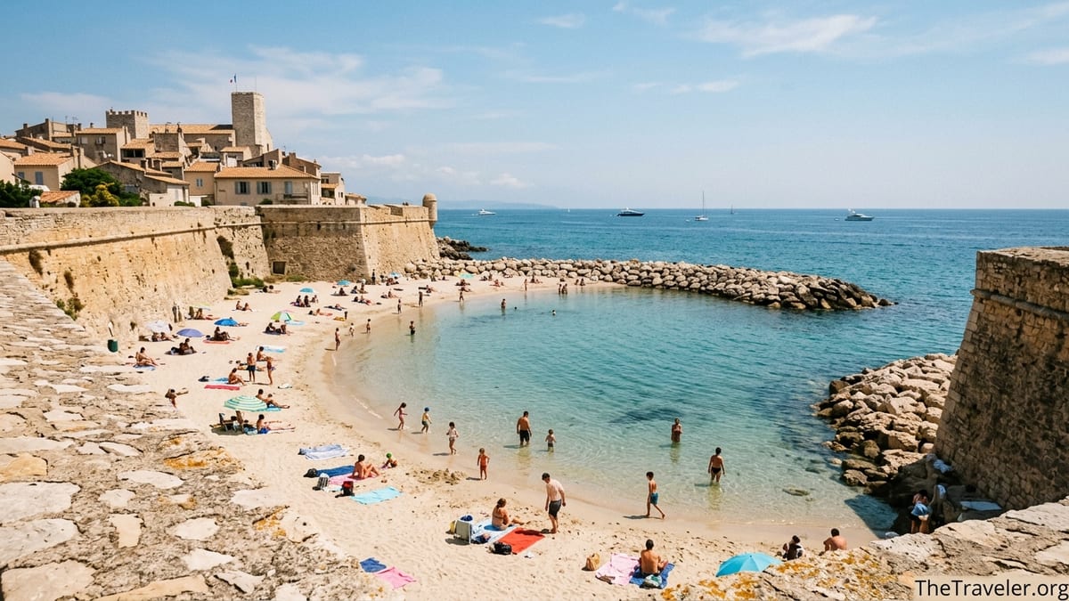 Sheltered cove of Plage de la Gravette in Antibes with calm water and stone ramparts.
