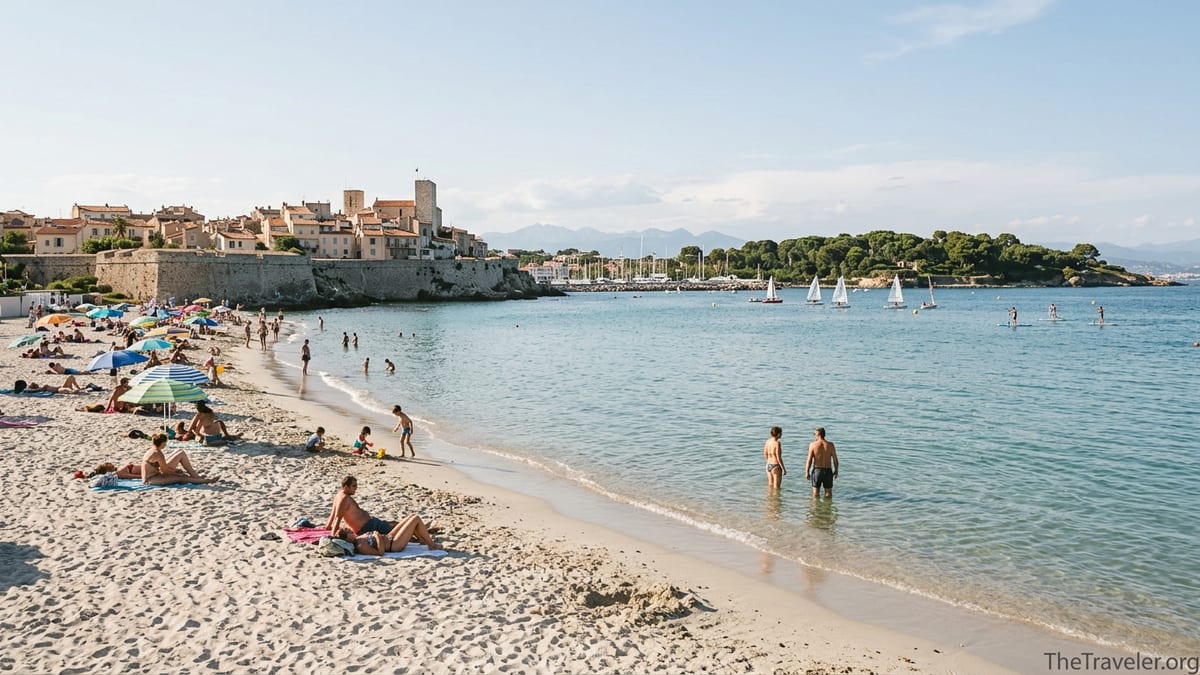 Plage de la Salis in Antibes with swimmers, pale sand, and views of the old town and Cap d’Antibes.