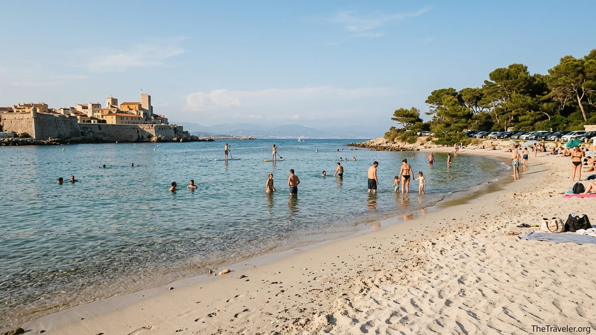 Afternoon view of Plage du Ponteil and Plage de la Salis in Antibes with swimmers and the old town in the background.