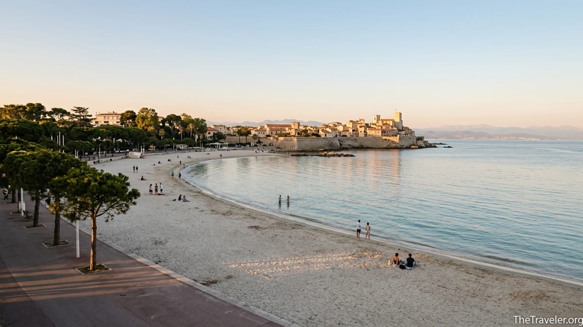 Soft golden hour light over a quiet Plage du Ponteil beach in Antibes with few visitors and calm sea.