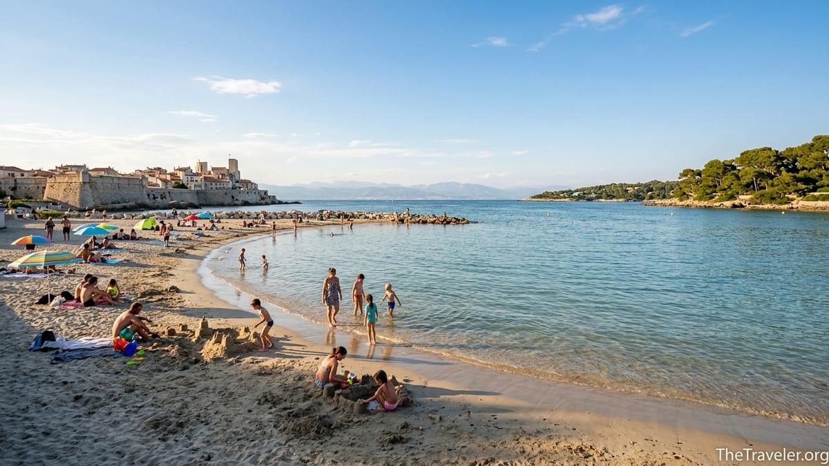 Families swimming and playing on the sandy shoreline of Plage du Ponteil in Antibes on a calm sunny afternoon.