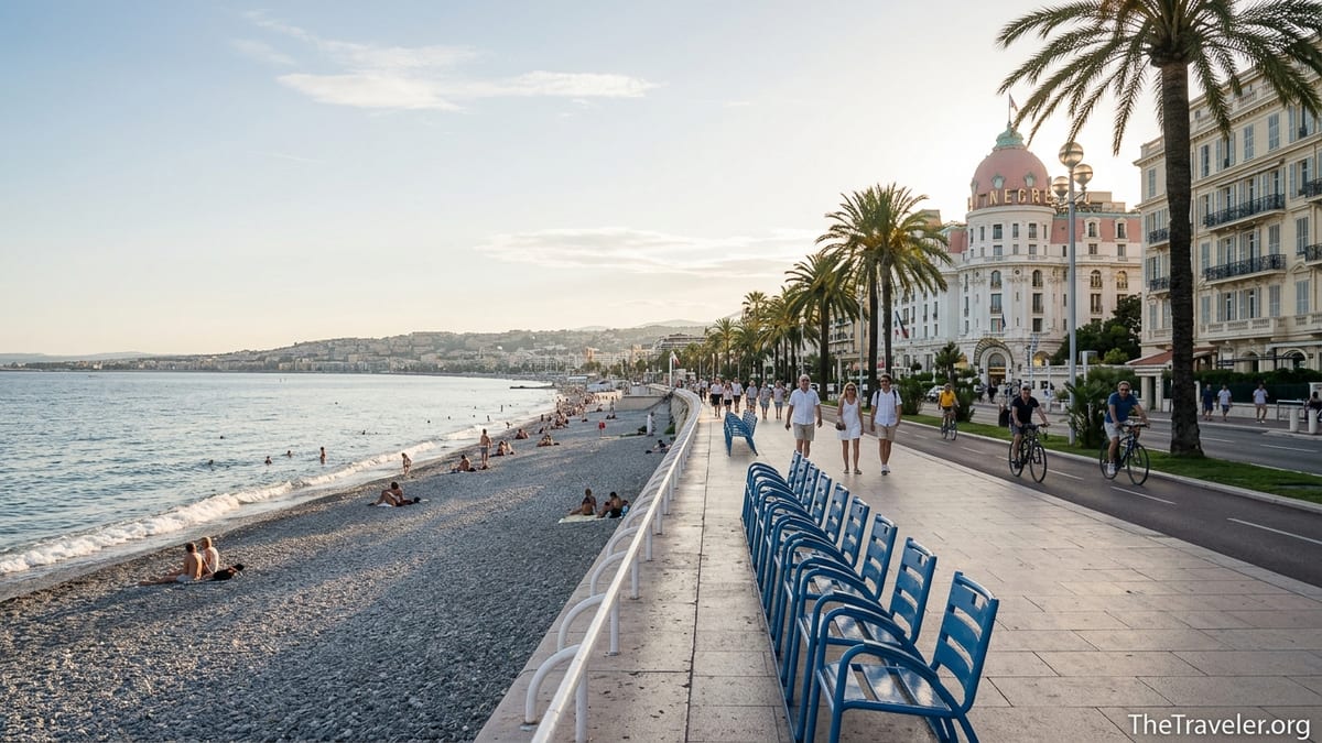 Late afternoon view along Nice’s Promenade des Anglais with blue chairs, palm trees and the Bay of Angels.