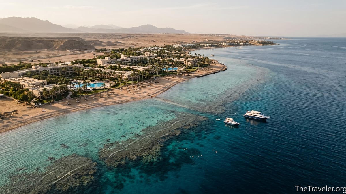 Aerial view of Egypt’s Red Sea Riviera with coral reef, boats and desert mountains at sunset.