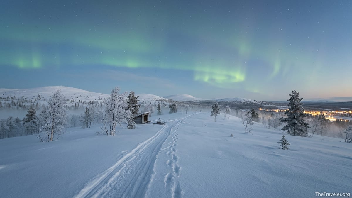 Snow-covered fells near Saariselkä at blue hour with faint Northern Lights overhead.