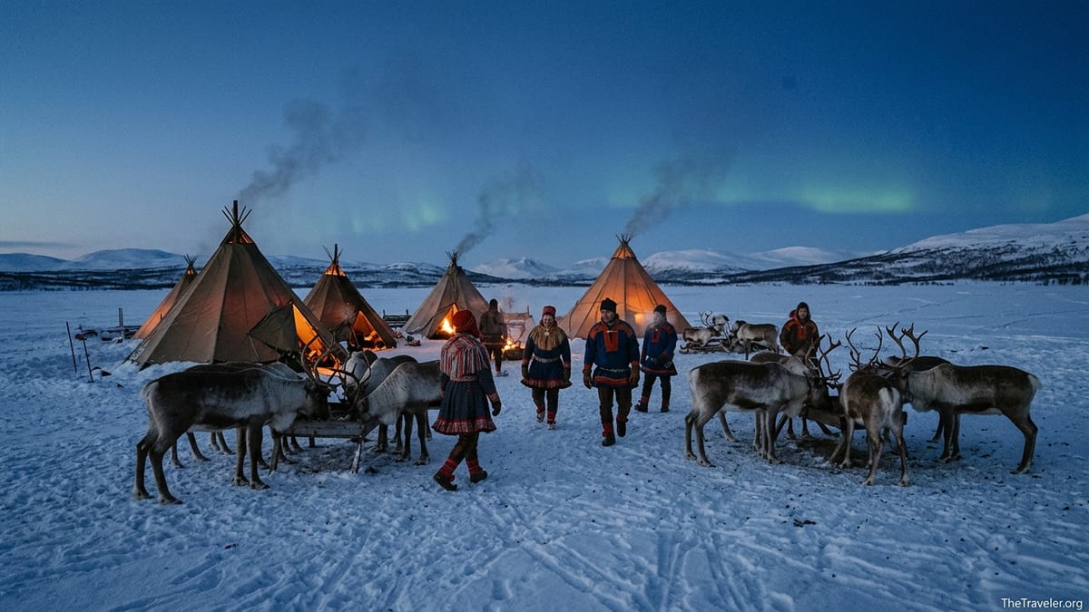 Sámi herders tending reindeer beside glowing lavvu tents on a snowy Arctic evening.