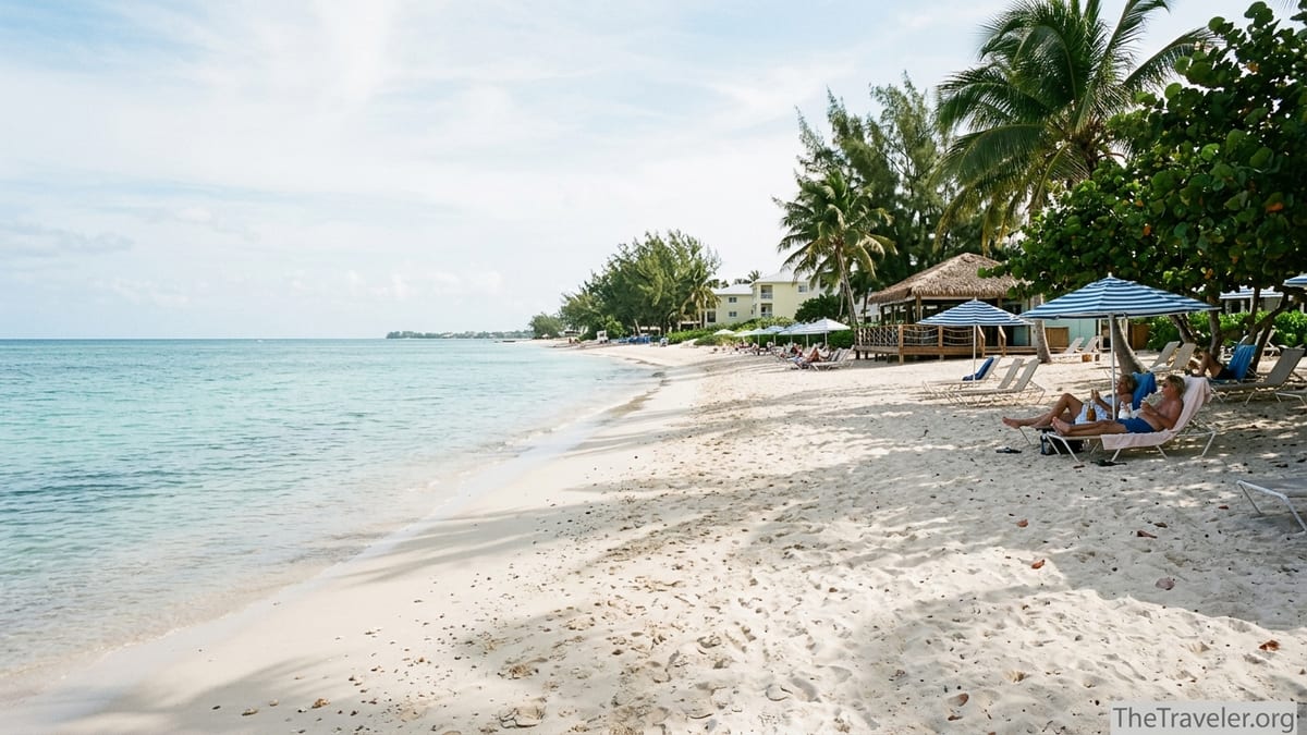 Loungers and umbrellas on Seven Mile Beach facing calm turquoise water in Grand Cayman.