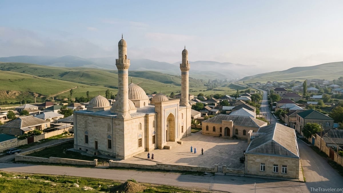 Juma Mosque in Shamakhi Azerbaijan with domes and minarets framed by green hills at sunset.