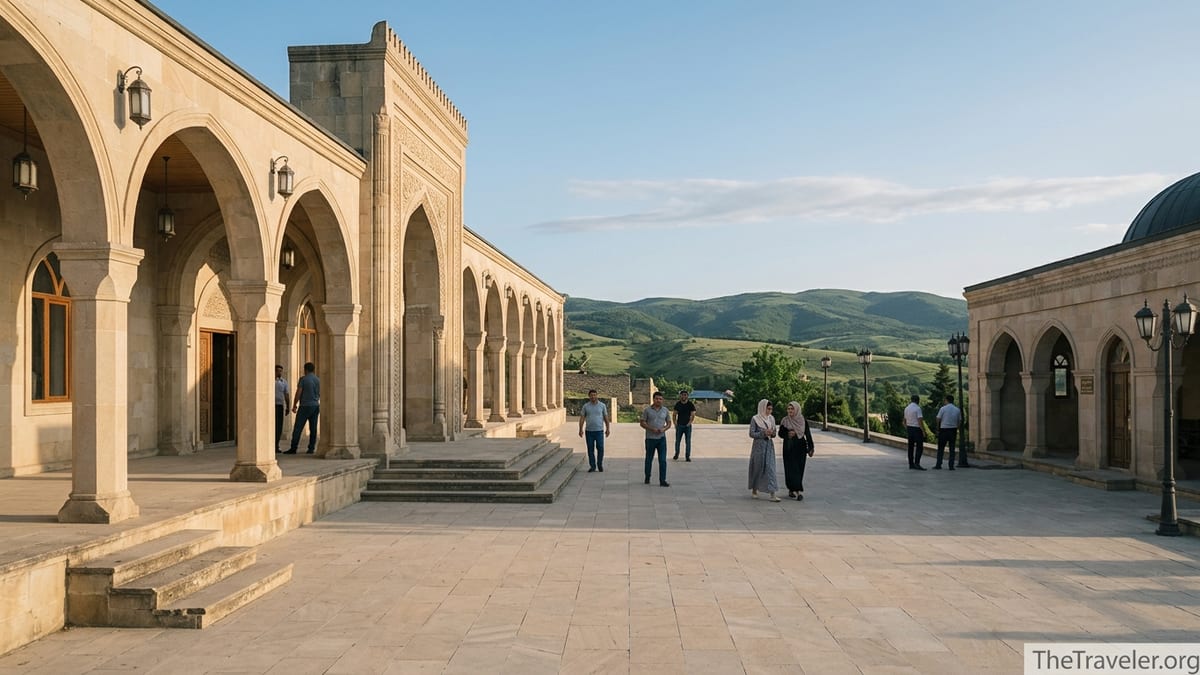 Shamakhi Juma Mosque courtyard with locals walking and green hills in the background