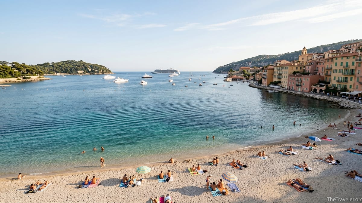 View of Villefranche-sur-Mer bay and Plage des Marinières with pastel hillside houses.