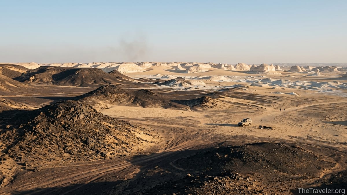 Chalk-white rock formations and a remote desert camp in Egypt’s Western Desert at sunrise.
